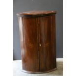 Georgian Mahogany Inlaid Bow Fronted Hanging Corner Cupboard, the two doors opening to reveal