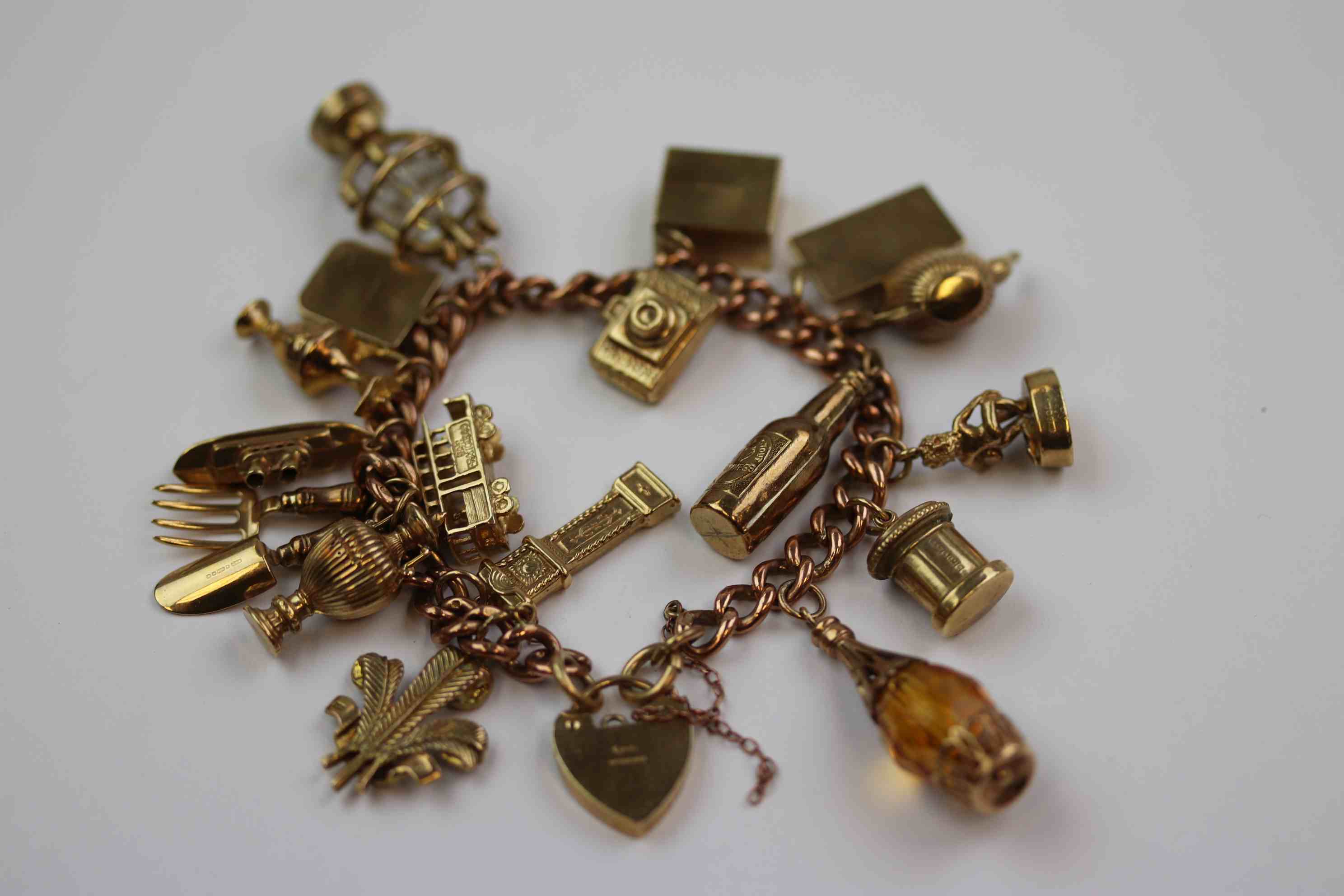 9ct rose gold curb link charm bracelet with 9ct yellow gold padlock clasp, seventeen charms in total - Image 2 of 12