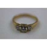 Diamond three stone unmarked gold ring, the central round brilliant cut diamond weight approximately