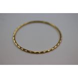 Unmarked yellow gold textured bangle, purchased in Dubai with receipt stating 22ct, inner