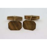Pair of 9ct gold bar cufflinks, the elongated octagonal panel with swirl decoration in relief,