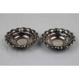 Pair of silver pin dishes, circular scalloped form each set with Austrian 2 Schilling coin dated