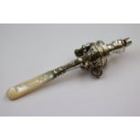 Mother-of-pearl handled white metal babies rattle, five bells (one deficient) with stylised