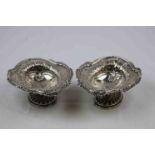 Pair of late Victorian silver pedestal trinket dishes, repousse foliate scroll decoration to broad