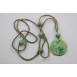 Carved jade necklace, the principle oval disc carved to depict bird, fruit and flowers suspended