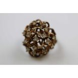 White stone set 9ct gold fancy cluster ring, circa 1970s, seventeen small round mixed cut white