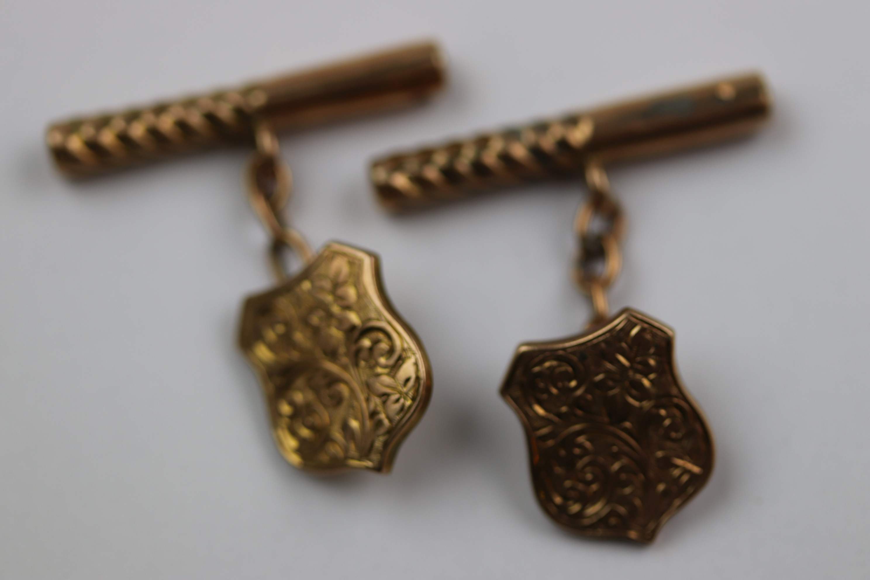 Pair of late Victorian 9ct rose gold chain link cufflinks, shield shaped foliate scroll engraved
