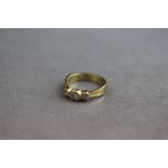 A diamond three stone yellow gold ring, the three round brilliant cut diamonds weighing