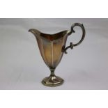 Edwardian silver milk jug of fluted helmet form raised on hexagonal foot, scroll handle, makers