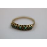 Emerald and diamond 9ct yellow gold dress ring comprising five small round mixed cut emeralds and