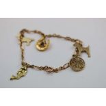 9ct rose gold figaro link charm bracelet with four 9ct yellow and rose gold charms attached and