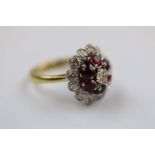 Diamond and ruby 18ct yellow gold platinum set three tier flower head cluster ring, the central