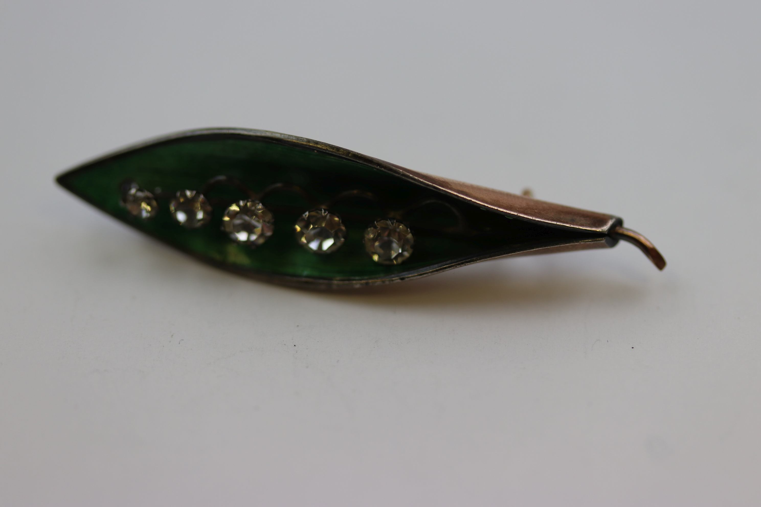 Enamelled gold plated brooch modelled as lily-of-the-valley, five graduated paste stones set to