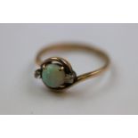 Opal and paste 14ct rose gold crossover ring, the central round cabochon cut precious white opal