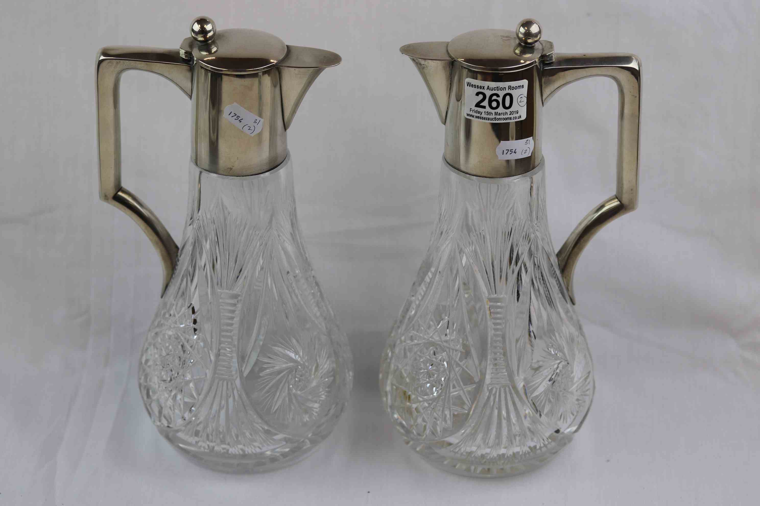 Pair of German silver mounted cut glass claret jugs, plain polished collar, hinged lid and handle,