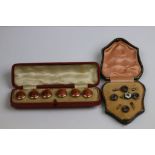 Leather cased set of mother-of-pearl dress studs and tie pin together with a leather cased set of