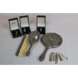 Pewter three piece dressing table brush set with cherub and foliate scroll decoration in relief;