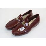 Pair of Vivienne Westwood Burgundy Rubber Shoes with attached enamel Orb logos, the souls and in-