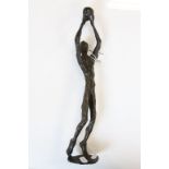 Abstract Bronze figure holding a Ball aloft with patinated finish, stands approx 33cm