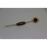 Garnet 9ct yellow gold stick pin, the circular cabochon cut garnet with star design surround,