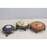 Three 19th century Circular Footstools, all with Needlework Tops and one with Three Carved Paw Feet