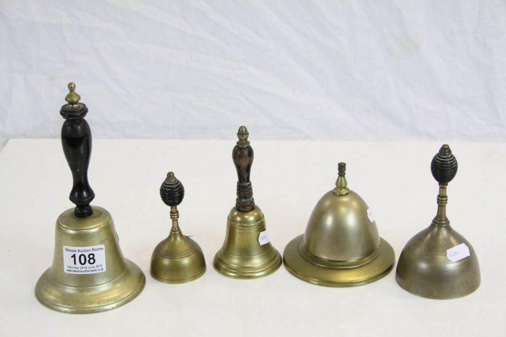 Four vintage Bronze hand Bells with ebonised Wooden handles plus a similar Counter top example