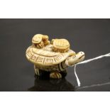 Bone netsuke figure of a Tortoise with two babies to shell