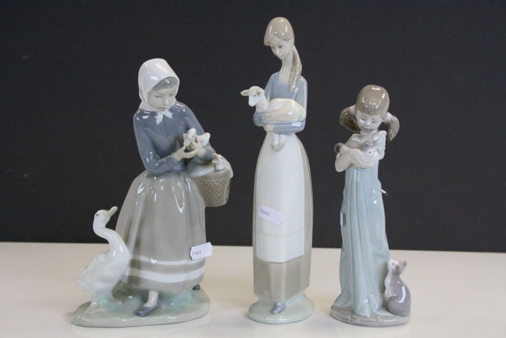 Three Lladro ceramic Figurines, one with Cats, another with Ducks and the third with a Lamb, tallest