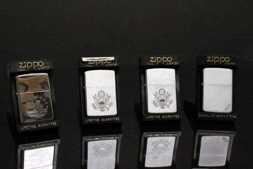 Four boxed vintage Zippo Lighters, three with American interest