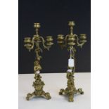 Continental pair of three branch Bronze Candlesticks, one with Cherub Writing, the other with Cherub