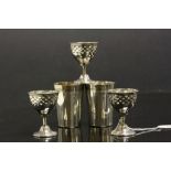 Three silver plated egg cups with two silver plated shot cups