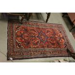 Red Ground Wool Rug decorated with Stylised Flowers, 165cms x 102cms