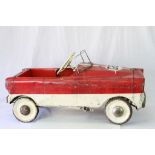 Vintage red and white pedal car with rusting and play wear, mid 20th C