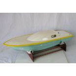 Fibreglass battery powered speed boat on wooden stand, 38" approx in length