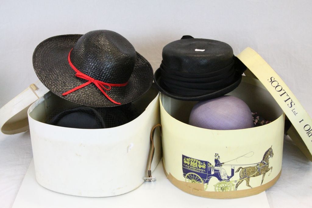 A quantity of ladies hats cpontained to two hat boxes.