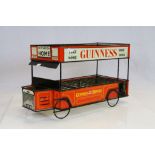 A mid 20th century tinplate advertising Guinness tram/bus bottle stand.