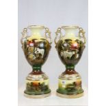 A pair of large continental twin handled urn vases with rural scene decoration.