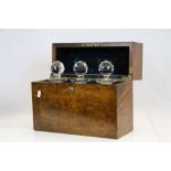 Walnut veneer Three bottle Tantalus Box with spring loaded key & three Cut Glass Decanters, the