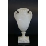 Large twin handled alabaster urn with naturalistic form decoration & on a square base
