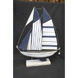 Large wooden sailing yacht with metal sails on a wooden base