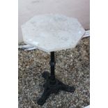 Garden table with wrought iron based with stone top in hexagonal form