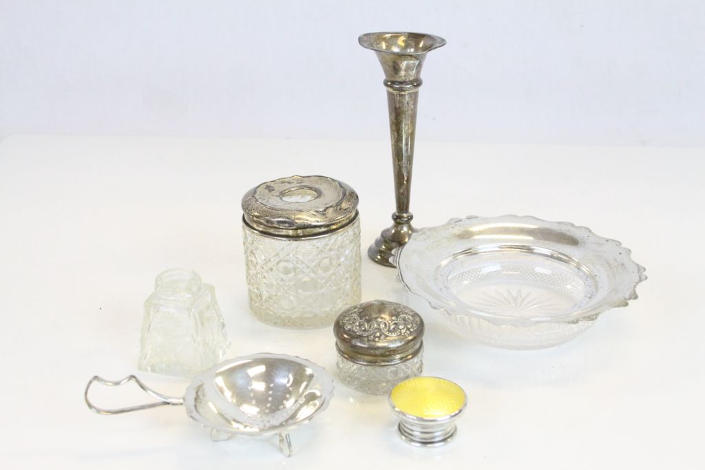 A small collection of hallmarked silver items to include a bud vase, various dressing table jars,