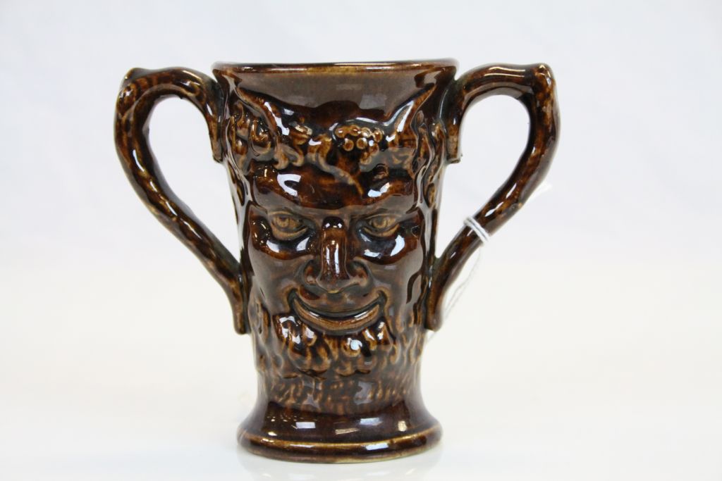 19th century treacle glaze loving cup decorated with two faces of Bacchus