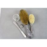 Two silver handled brushes plus a silver locket, silver collared knife and glass pot