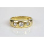 A late Victorian diamond three stone 18ct yellow gold ring, three graduated gypsy set old cut