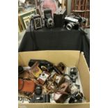 A box of vintage cameras and fishing reels.