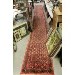 Red Ground Runner Rug with Stylised Floral Pattern within a Border, 687cms long x 80cms wide