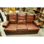 Brown leather three seater chesterfield style sofa.