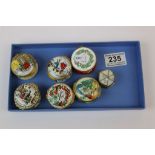 Six vintage Halcyon Days Enamel pill boxes and a white metal example with Mother of Pearl lid