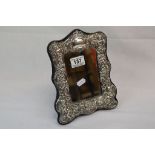 A hallmarked silver easel back mirror with cherub decoration.